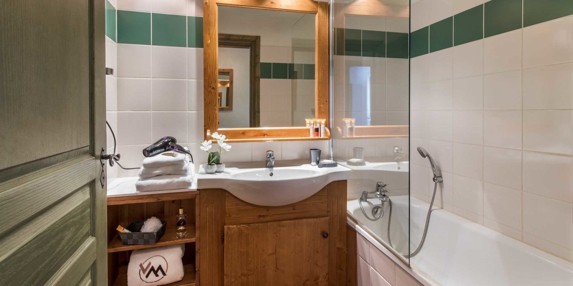 Residences Village Montana Tignes Tignes-Val d'Isere Frankrijk wintersport skivakantie luxe badkamer bad spiegel wastafel fohn handdoeken groene rand tegels