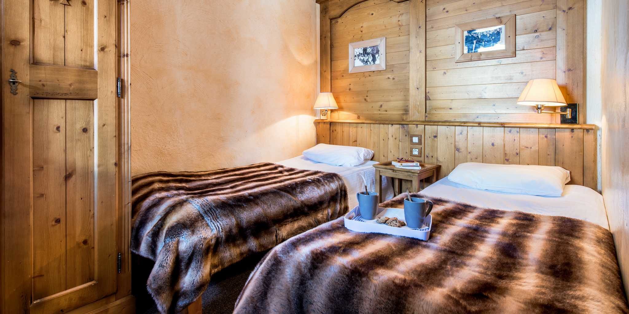Residences Village Montana Tignes Tignes-Val d'Isere Frankrijk wintersport skivakantie luxe slaapkamer aparte bedden theekopjes koekjes houten wand schilderijen wandlampjes
