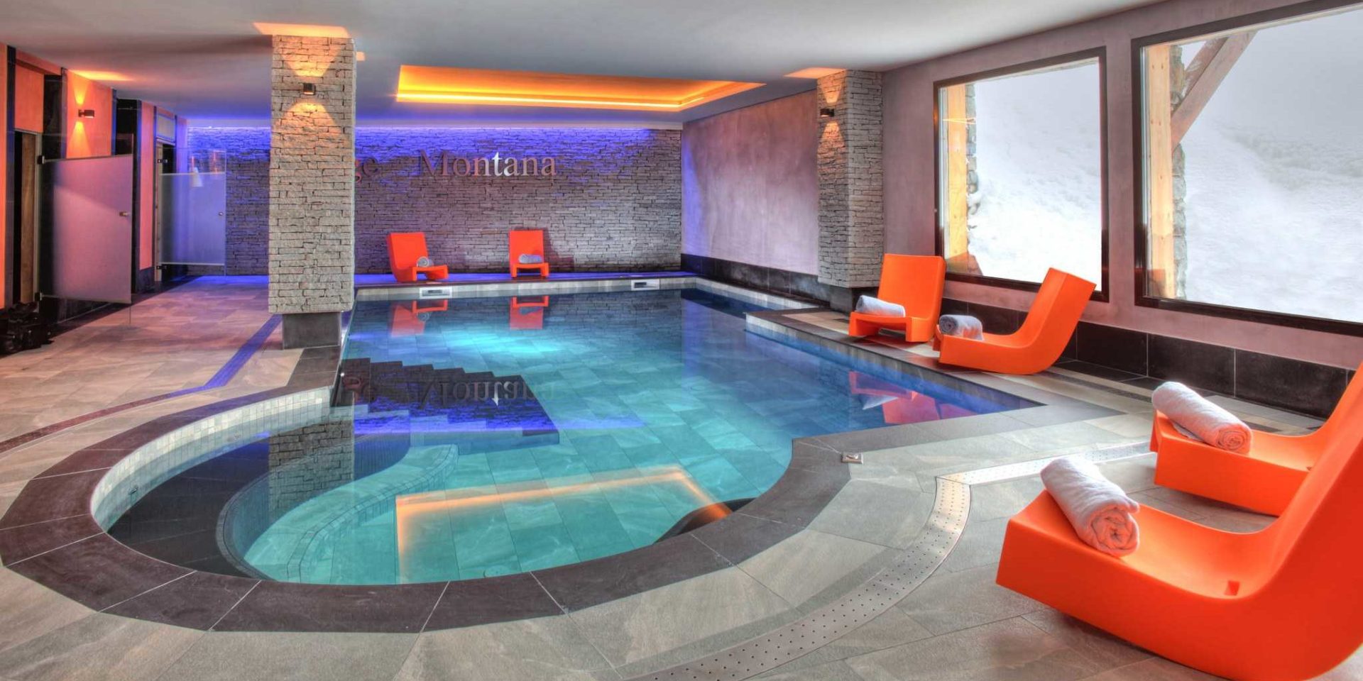 Residence Montana Plein Sud Val Thorens Les 3 Vallees Frankrijk wintersport skivakantie luxe zwembad trap oranje ligstoelen handdoeken Montana grote ramen sneeuw zwemmen ontspannen relaxen genieten