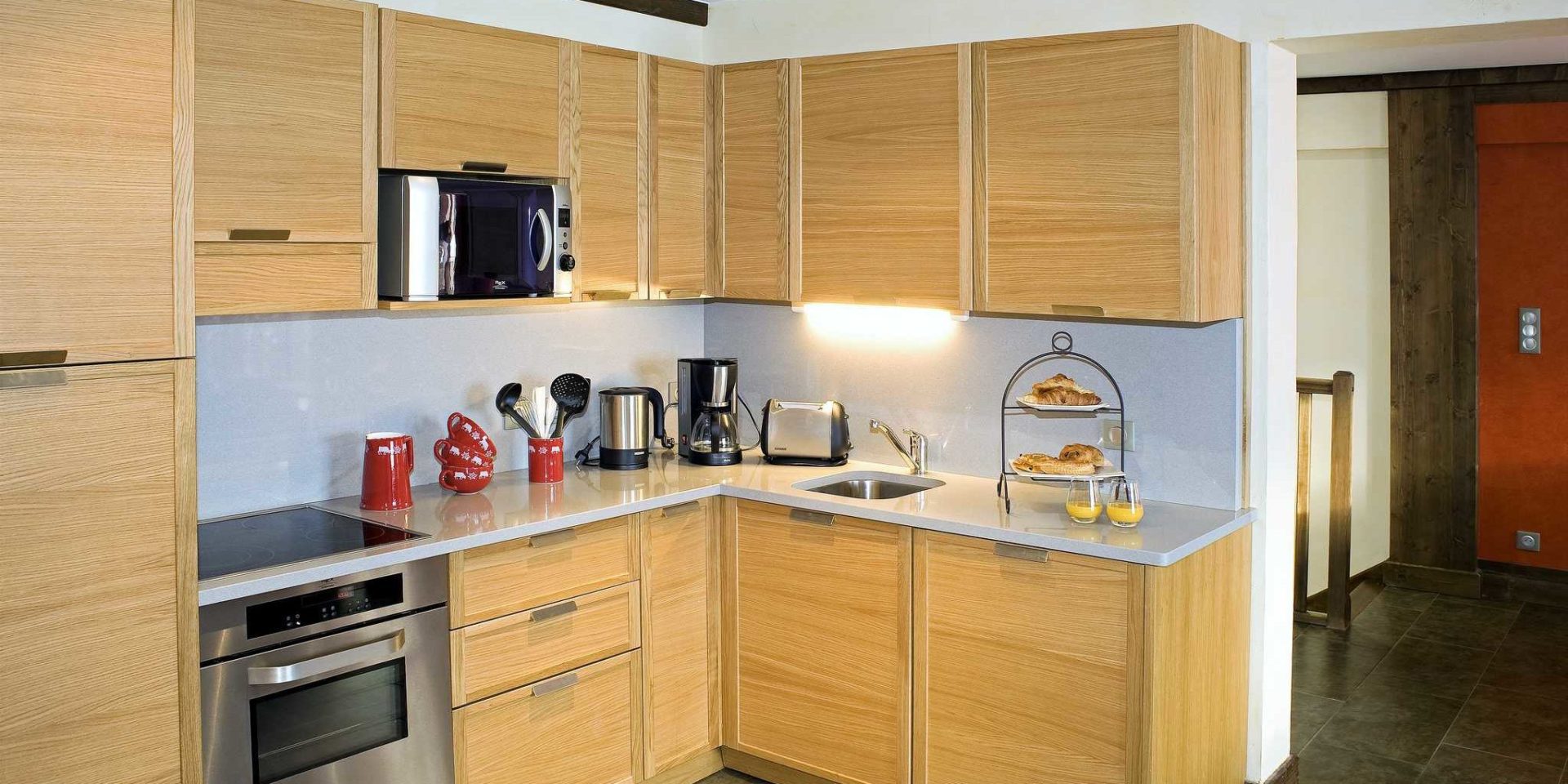 Residences Village Montana Val Thorens Les 3 Vallees Frankrijk wintersport skivakantie luxe keuken 5K8 houten kastjes koekjes jus d'orange rode bakjes
