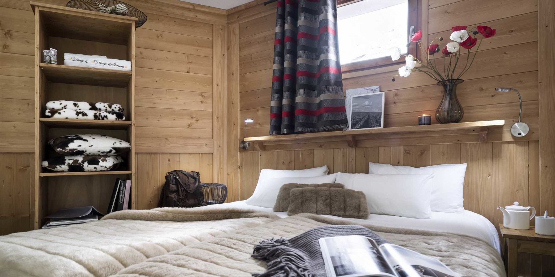 Residences Village Montana Val Thorens Les 3 Vallees Frankrijk wintersport skivakantie luxe slaapkamer 2-persoonsbed sprei tas kussens kleden mandjes bloemen fotolijstjes raam tafeltje theepot gestreept gordijn houten wanden