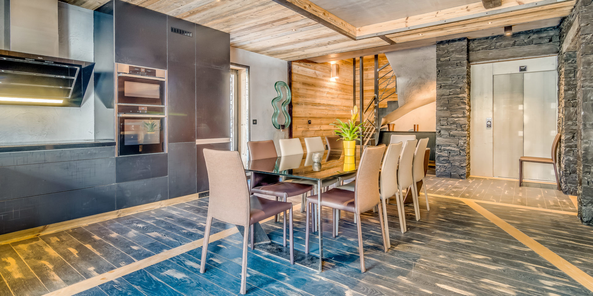 Chalet Babylon Tignes Les Brevieres Tignes-Val d'Isere Frankrijk wintersport skivakantie luxe eetkamer eettafel stoelen kunst keuken houten balken lift trap