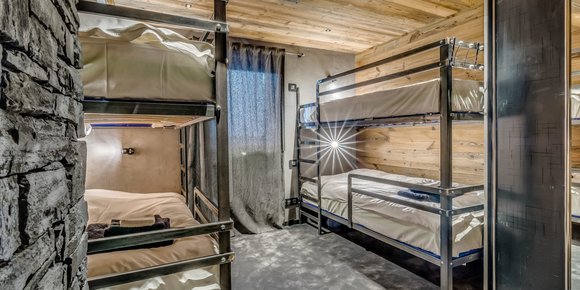 Chalet Babylon Tignes Les Brevieres Tignes-Val d'Isere Frankrijk wintersport skivakantie luxe slaapkamer 2 stapelbedden handdoeken gordijn hout