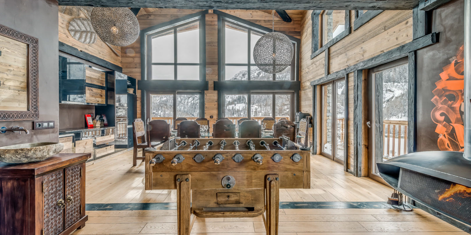Chalet Ubud Tignes Les Brevieres Tignes-Val d'Isere Frankrijk wintersport skivakantie luxe living tafelvoetbal wasbak lampen eetkamer keuken hoge ramen hout uitzicht sneeuw