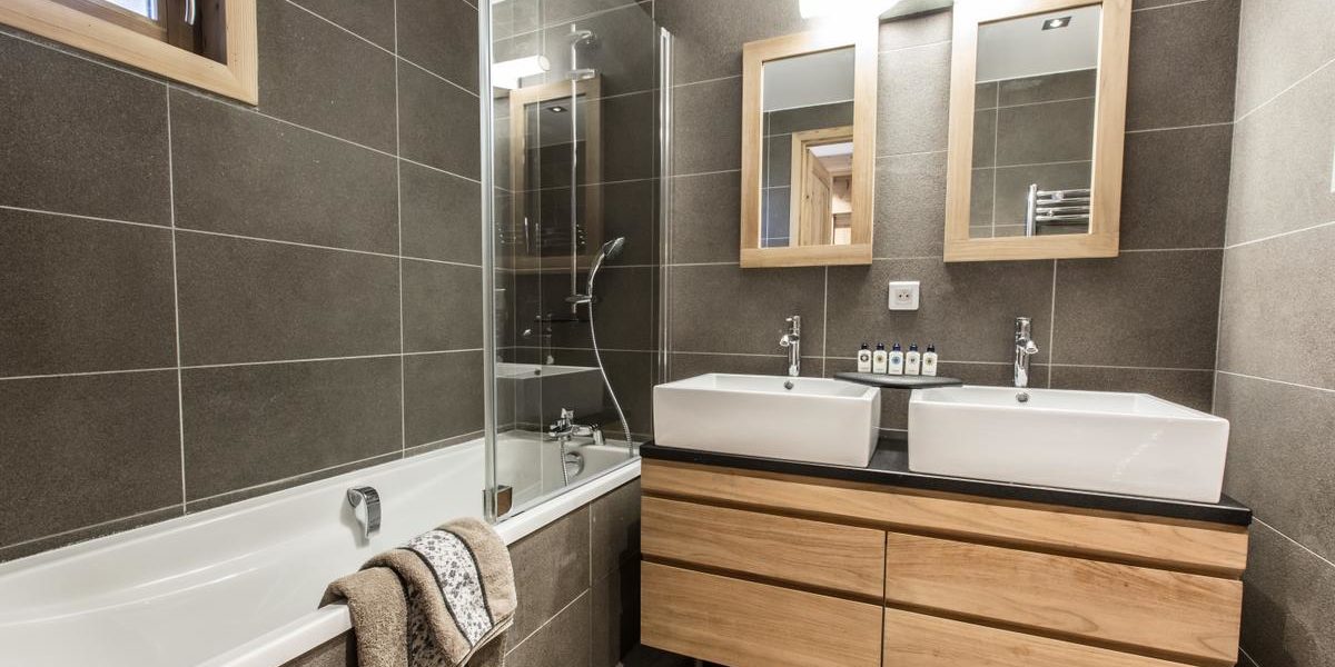 Alpine Residences Courchevel Les 3 Vallees Frankrijk wintersport skivakantie luxe Aspen Lodge badkamer bad handdoeken dubbele wasbak spiegels raam