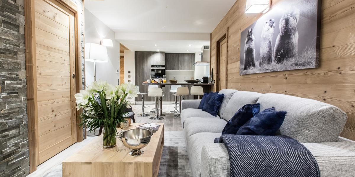 Alpine Residences Courchevel Les 3 Vallees Frankrijk wintersport skivakantie luxe Keystone Lodge living bank kleed bloemen schilderij marmotten gedekte eettafel barkrukken hout