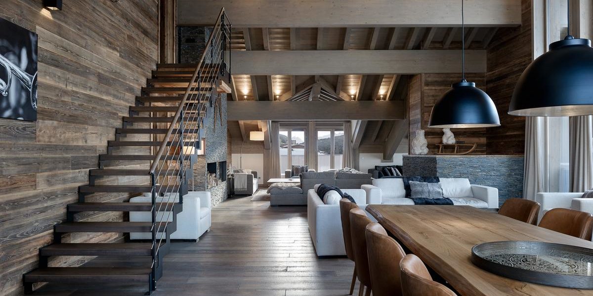 Alpine Residences Courchevel Les 3 Vallees Frankrijk wintersport skivakantie luxe Mammoth Lodge eetkamer hanglampen banken living trap klok schilderij houten balken ramen