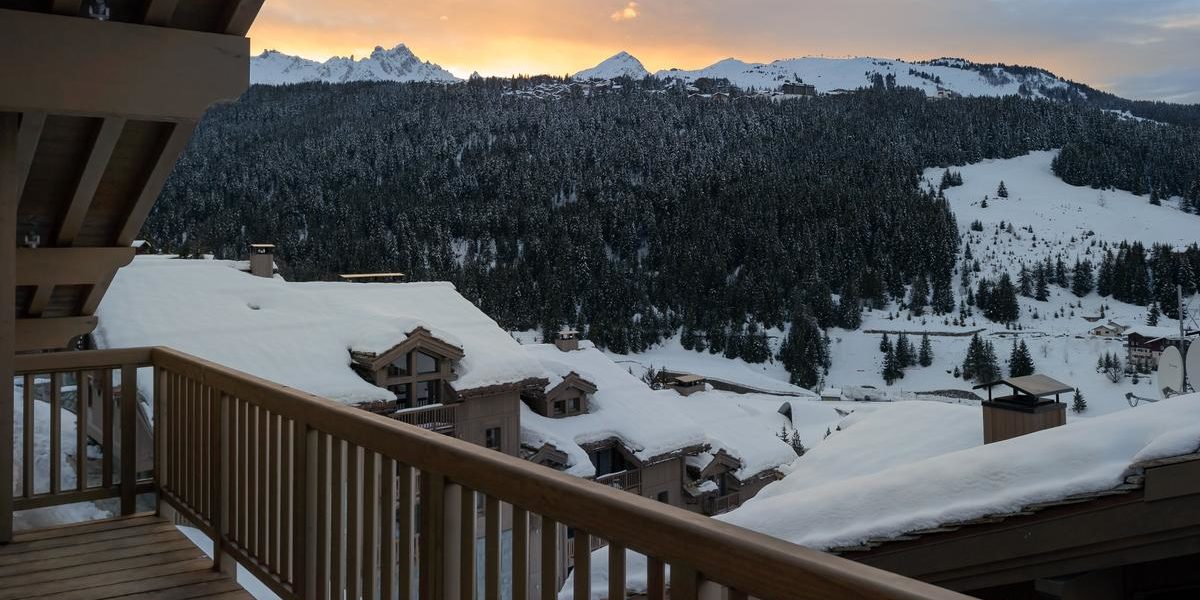 Alpine Residences Courchevel Les 3 Vallees Frankrijk wintersport skivakantie luxe Residence Le C balkon uitzicht dorp besneeuwde daken bomen besneeuwde bergen sneeuw