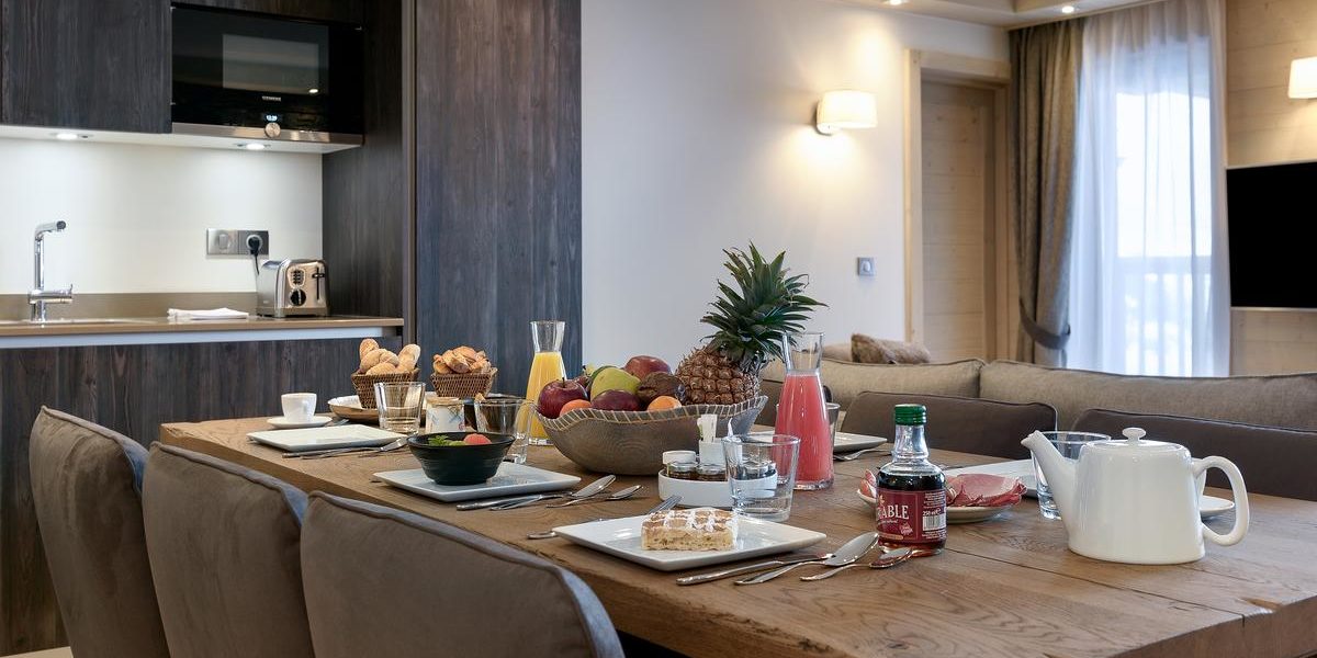 Alpine Residences Courchevel Les 3 Vallees Frankrijk wintersport skivakantie luxe Residence Le C eetkamer gedekte tafel ontbijt broodjes fruit ananas keuken