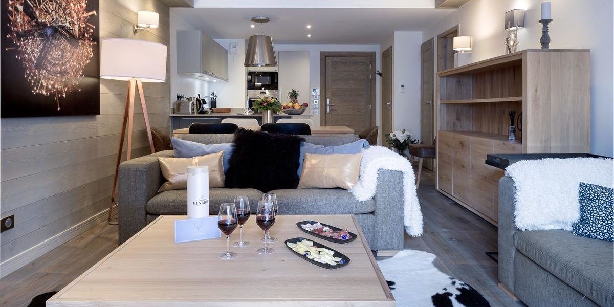 Alpine Residences Courchevel Les 3 Vallees Frankrijk wintersport skivakantie luxe Residence Le C living banken vloerkleed wijnglazen hapjes schilderij lamp kast eetkamer keuken