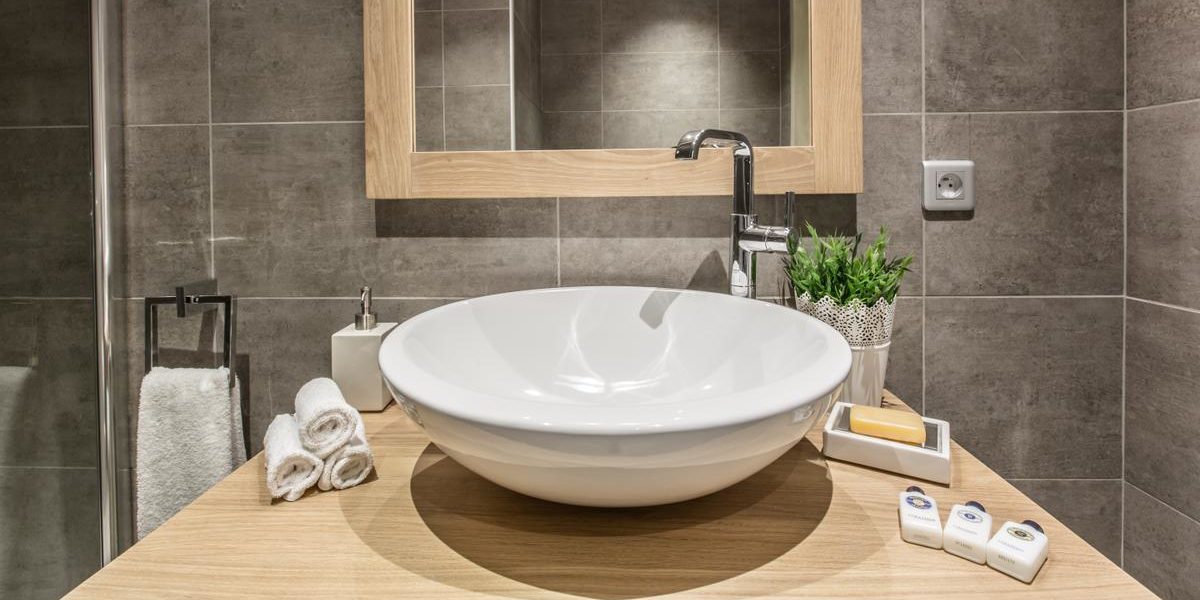 Alpine Residences Courchevel Les 3 Vallees Frankrijk wintersport skivakantie luxe Whistler Lodge badkamer wastafel spiegel handdoeken badproducten plant