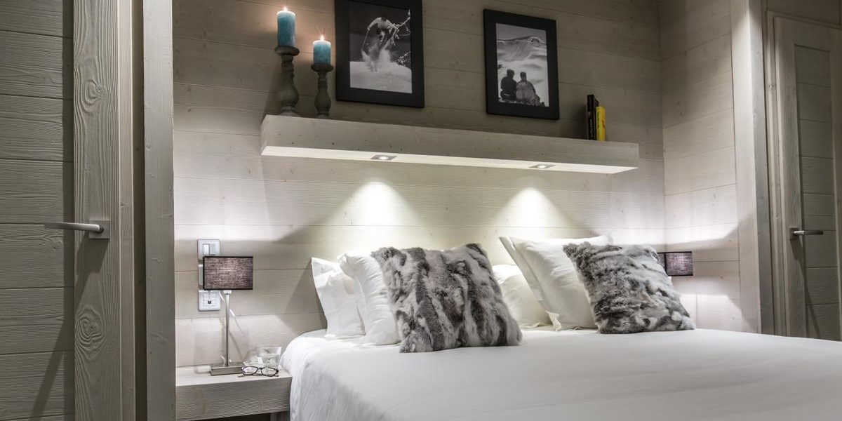 Alpine Residences Courchevel Les 3 Vallees Frankrijk wintersport skivakantie luxe Whistler Lodge slaapkamer 2-persoonsbed kussens schilderijen kaarsen nachtlampje