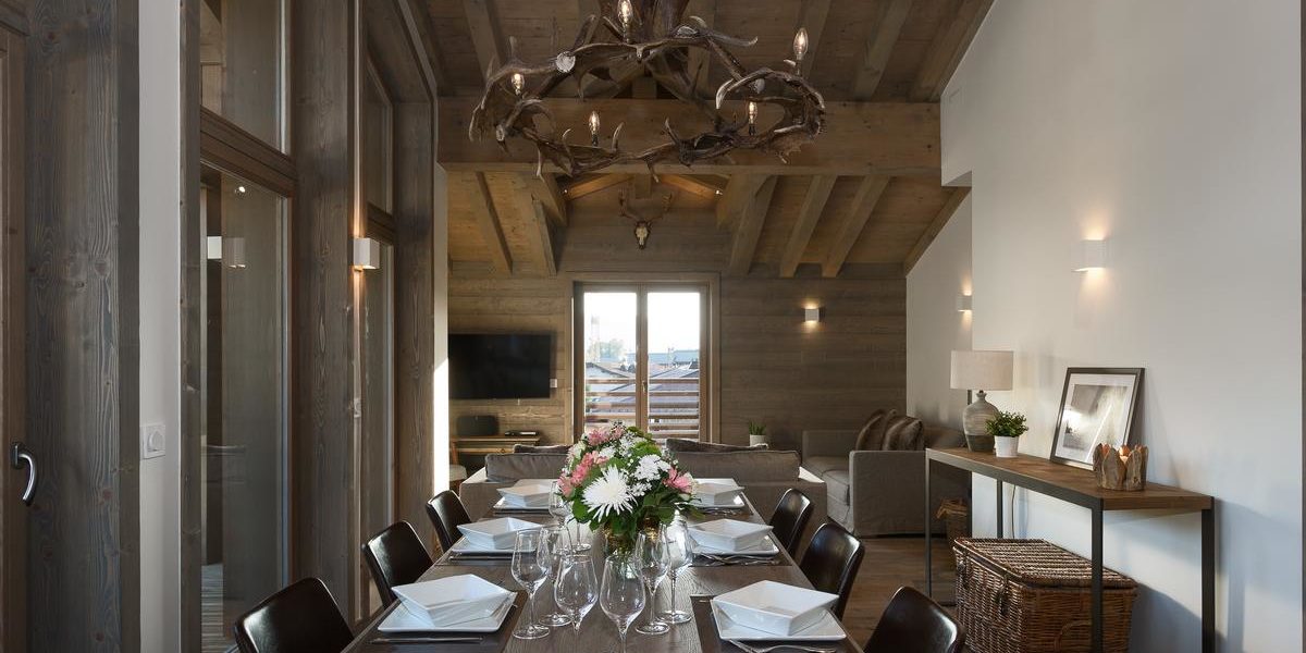 Alpine Residences Les Gets Les Portes du Soleil Frankrijk wintersport skivakantie luxe Annapurna eetkamer gedekte tafel bloemen hanglamp mand bank TV houten balken ramen