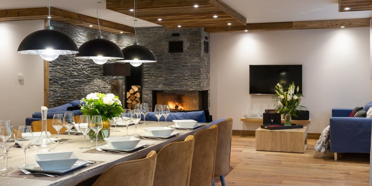 Alpine Residences Les Gets Les Portes du Soleil Frankrijk wintersport skivakantie luxe Annapurna eetkamer gedekte tafel wijnglazen bloemen hanglampen open haard bank TV
