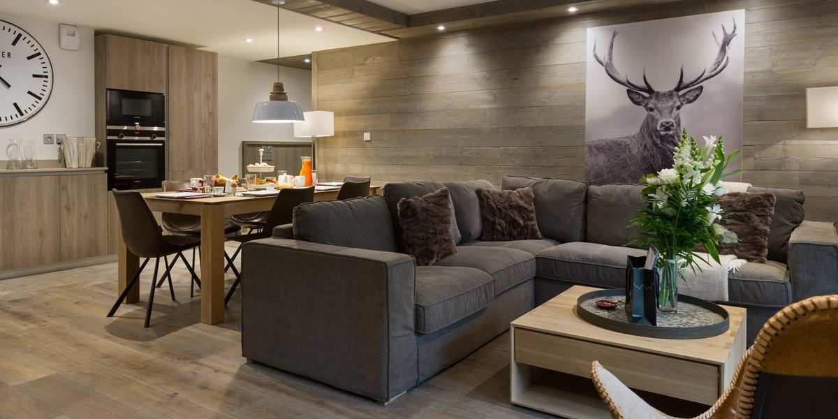 Alpine Residences Les Gets Les Portes du Soleil Frankrijk wintersport skivakantie luxe Annapurna living hoekbank plant schilderij hert eetkamer gedekte tafel ontbijt keuken klok