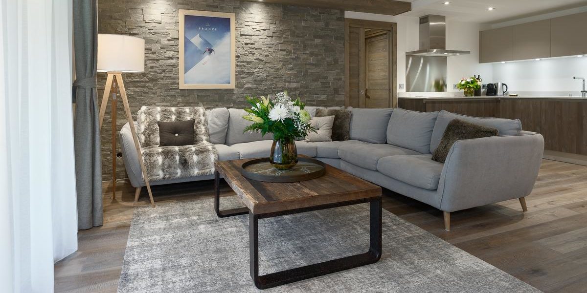 Alpine Residences Les Gets Les Portes du Soleil Frankrijk wintersport skivakantie luxe Annapurna living hoekbank salontafel bloemen vloerkleed schilderij lamp keuken