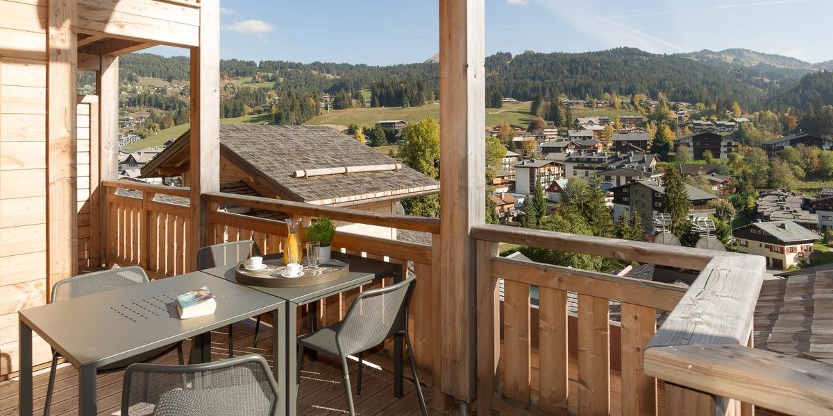 Alpine Residences Les Gets Les Portes du Soleil Frankrijk wintersport skivakantie luxe Kilimandjaro balkon tafel stoelen uitzicht dorp bomen bergen