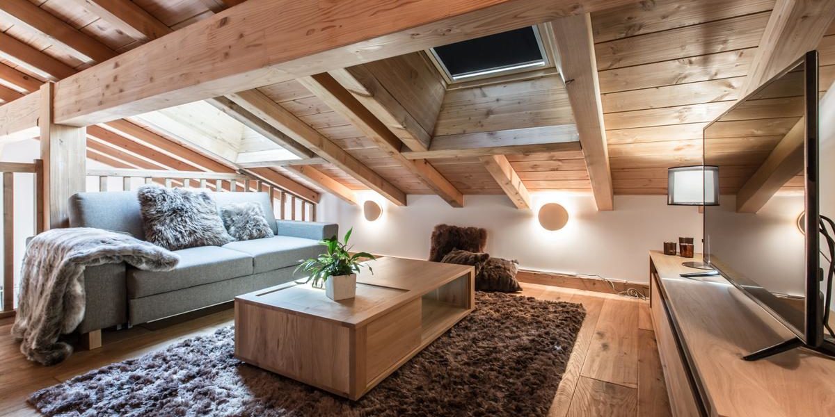 Alpine Residences Les Gets Les Portes du Soleil Frankrijk wintersport skivakantie luxe Kilimandjaro bank kussens kleed vloerkleed plant TV verlichting dakraam houten balken