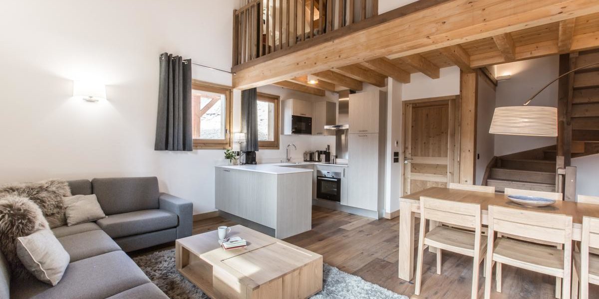 Alpine Residences Les Gets Les Portes du Soleil Frankrijk wintersport skivakantie luxe Kilimandjaro living hoekbank vloerkleed eettafel stoelen keuken trap mezzanine