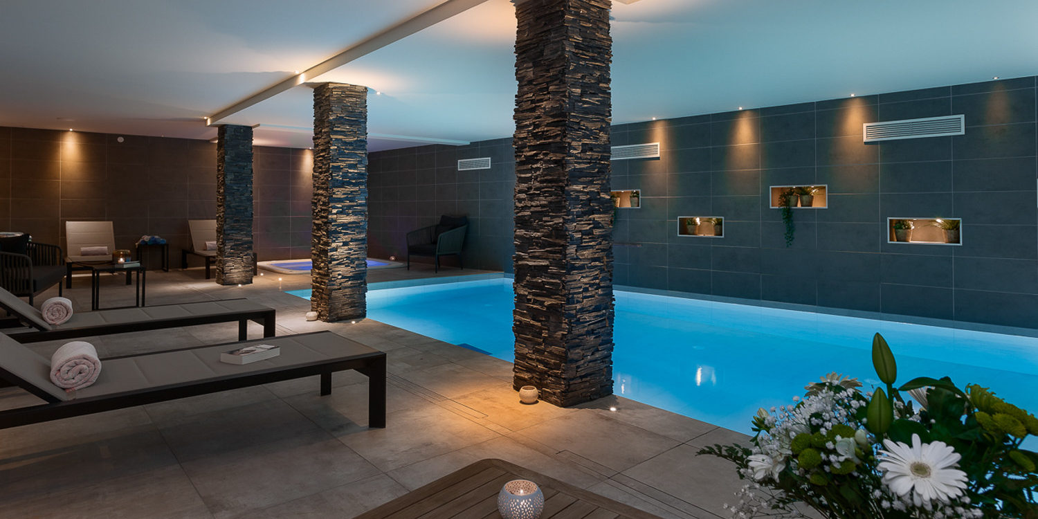 Alpine Residences Les Gets Les Portes du Soleil Frankrijk wintersport skivakantie luxe zwembad bloemen ligstoelen verlichting ontspannen relaxen genieten