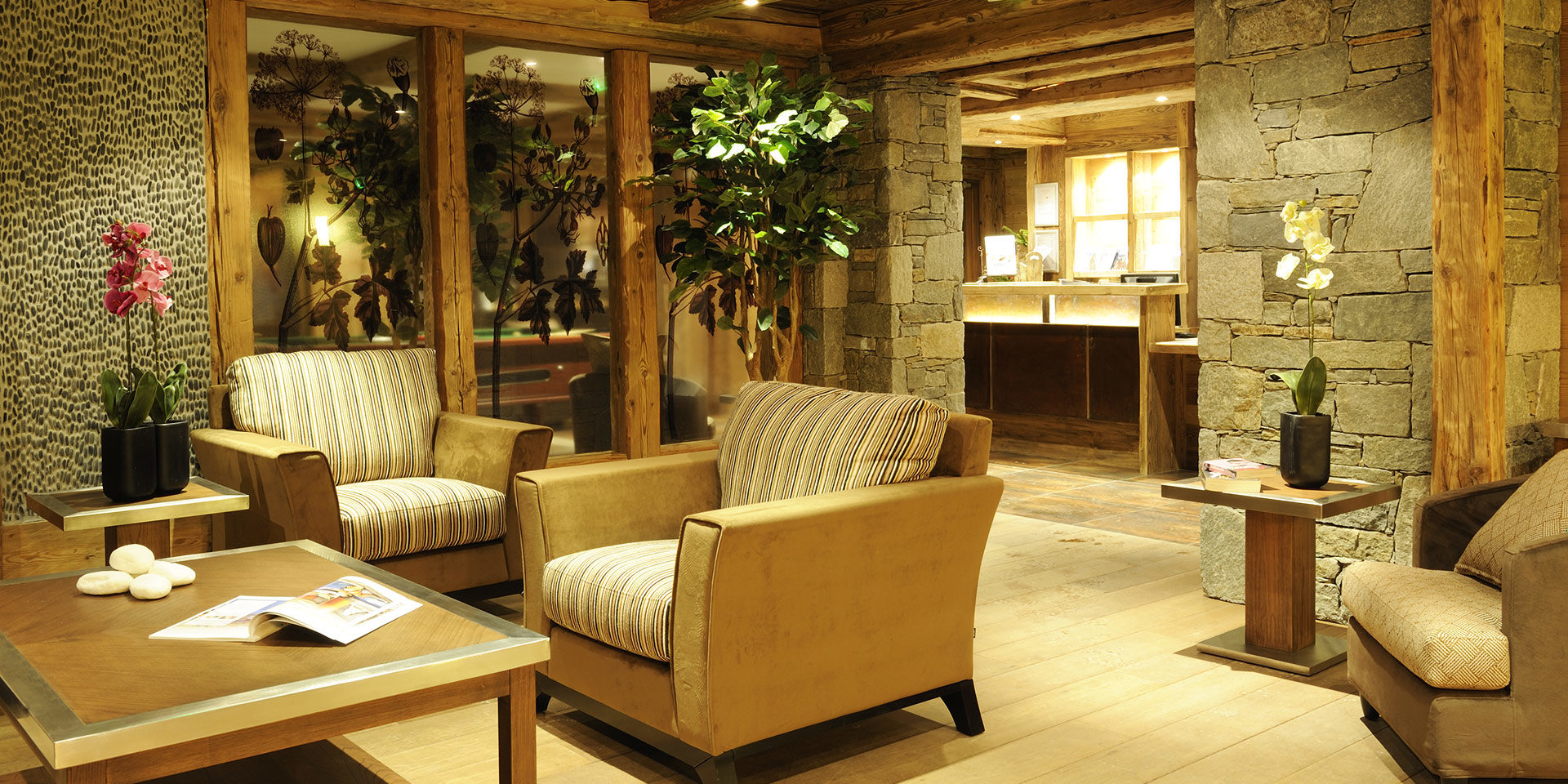 CGH L'Oree des Neiges Vallandry Paradiski Frankrijk wintersport skivakantie luxe receptie fauteuils Orchidee stenen muren hout planten raam