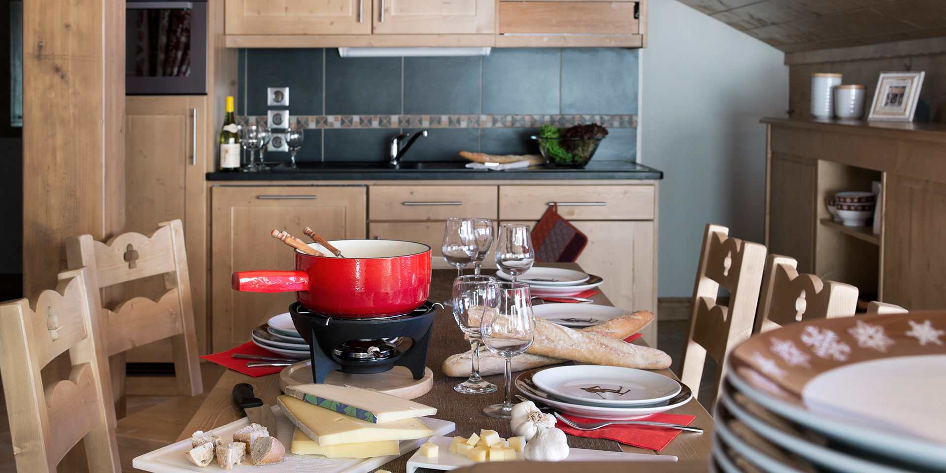 CGH Le Chalet des Dolines Montgenevre Via Lattea Frankrijk wintersport skivakantie luxe gedekte tafel fondue stokbrood kaas wijnglazen keuken