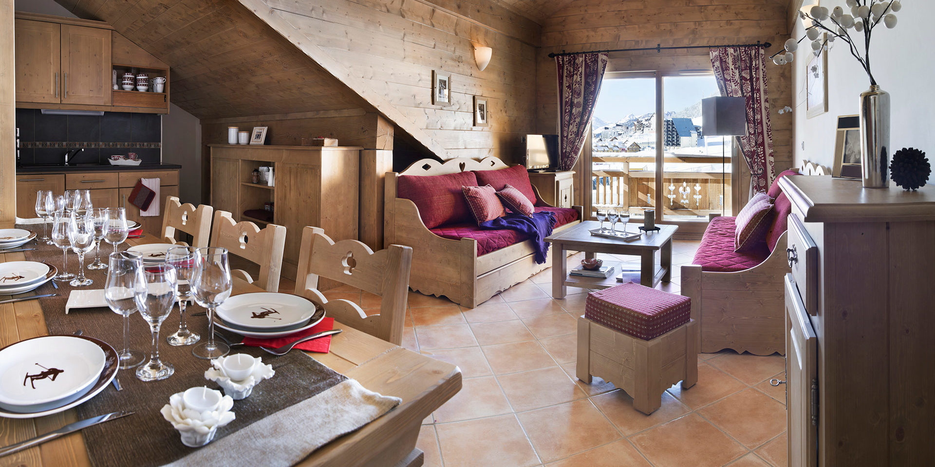 CGH Le Chalet des Dolines Montgenevre Via Lattea Frankrijk wintersport skivakantie luxe gedekte tafel wijnglazen keuken zithoek banken hocker raam balkon sneeuw