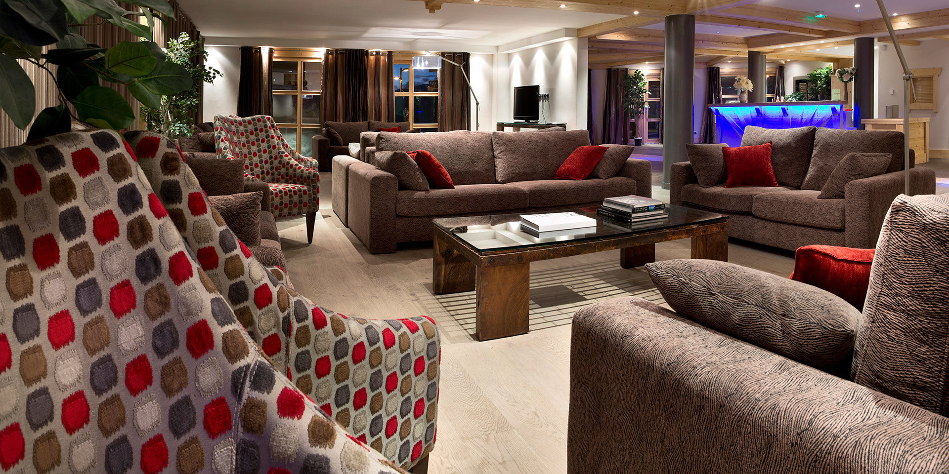 CGH Le Cristal de l'Alpe Alpe d' Huez Grand Domaine Frankrijk wintersport skivakantie luxe receptie banken fauteuils kussens boeken TV ramen houten balken