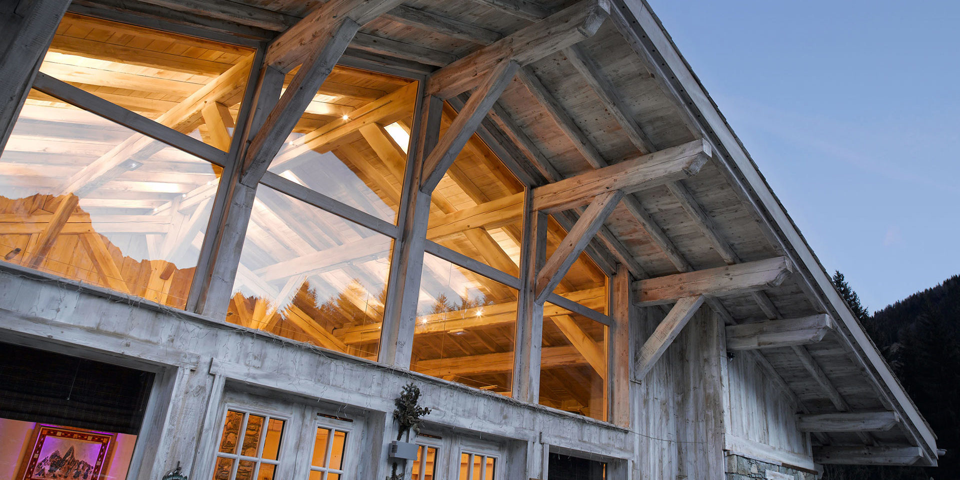 CGH Le Hameau de Pierre Blanche Les Houches Chamonix Mont Blanc Frankrijk wintersport skivakantie luxe facade grote hoge ramen houten balken bomen