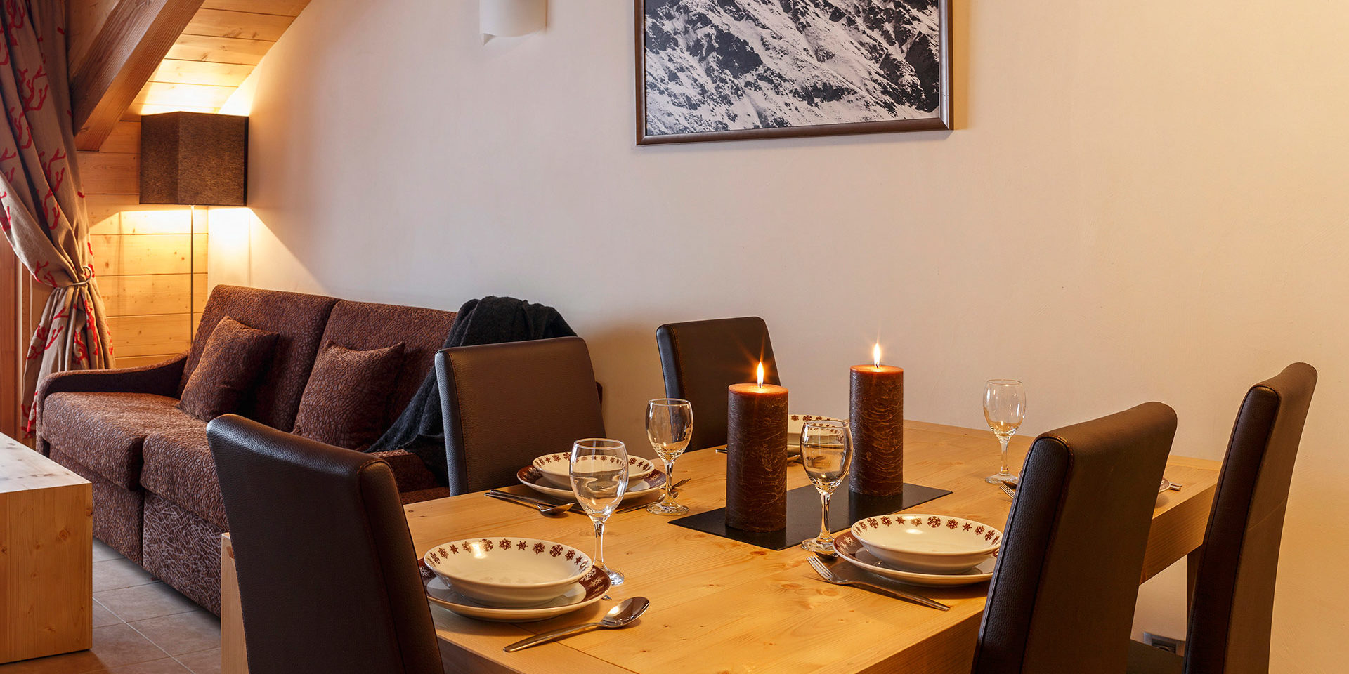 CGH Le Napoleon Montgenevre Via Lattea Frankrijk wintersport skivakantie luxe gedekte eettafel stoelen bank schilderij houten balken gordijnen