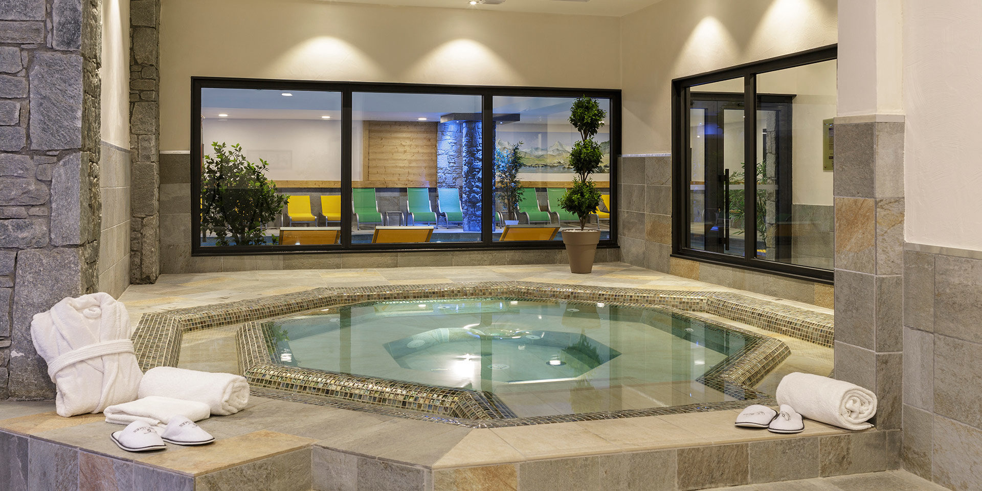 CGH Le Napoleon Montgenevre Via Lattea Frankrijk wintersport skivakantie luxe jacuzzi wellness handdoeken badjas slippers planten raam ligstoelen zwembad