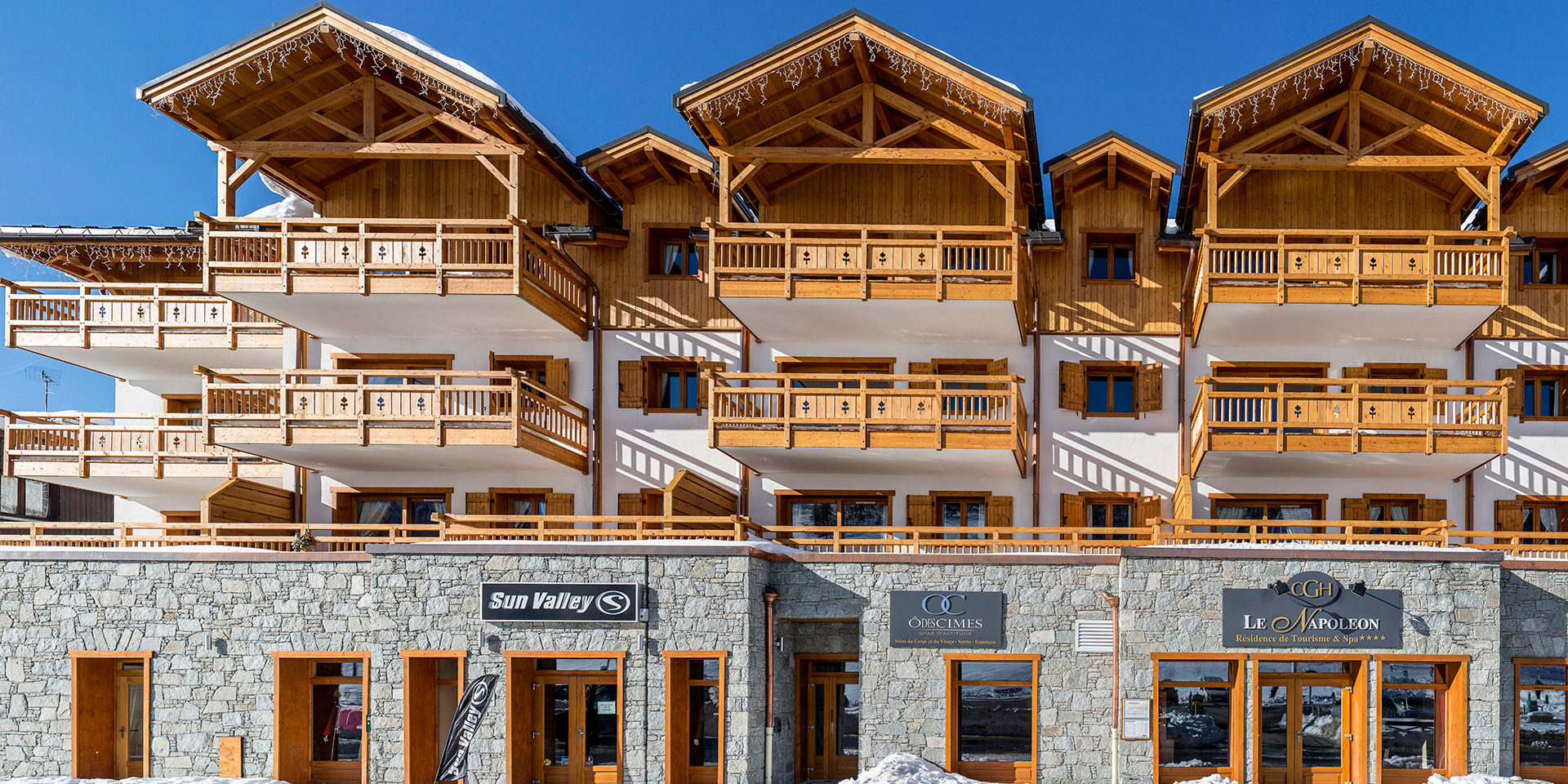 CGH Le Napoleon Montgenevre Via Lattea Frankrijk wintersport skivakantie luxe residence 4 sterren hout balkons stenen blauwe lucht
