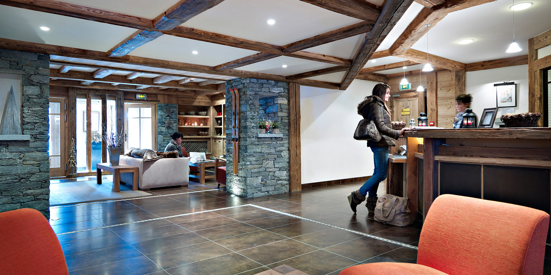 CGH Le Ruitor Sainte Foy Sainte Foy Tarentaise Frankrijk wintersport skivakantie luxe receptie bank oranje fauteuils plavuizen houten balken kleed