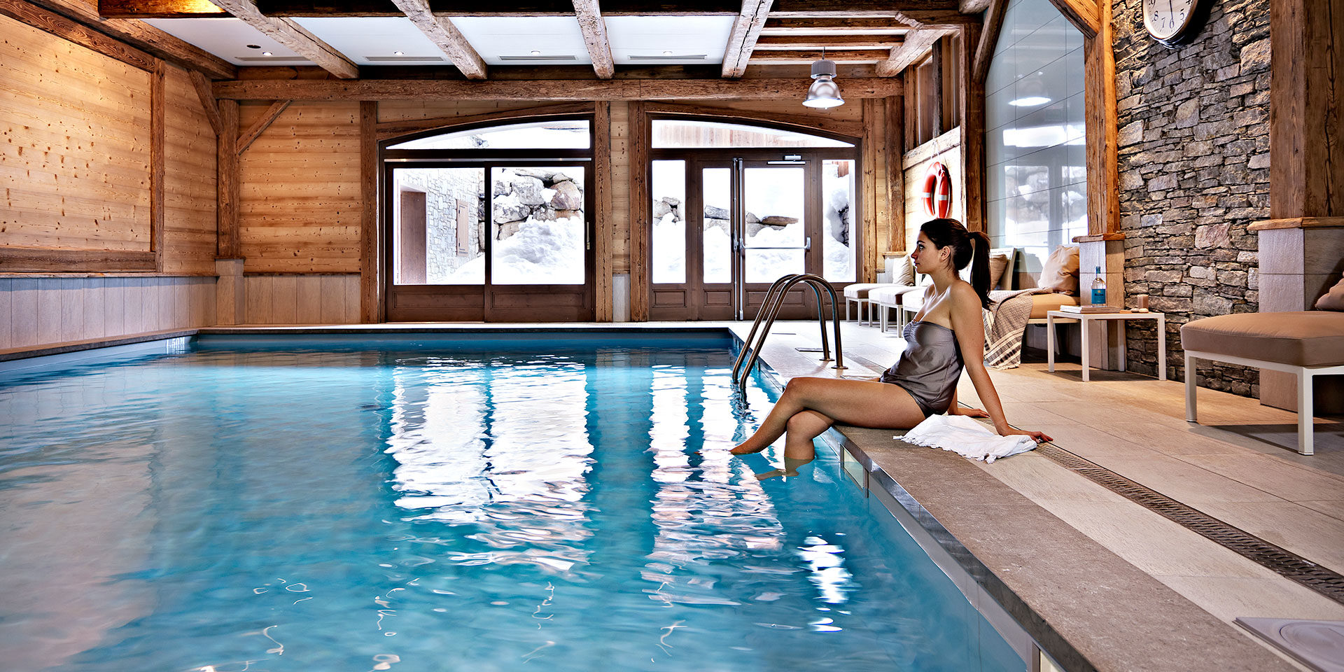 CGH Le Ruitor Sainte Foy Sainte Foy Tarentaise Frankrijk wintersport skivakantie luxe zwembad stoelen dame houten balken raam ontspannen relaxen genieten