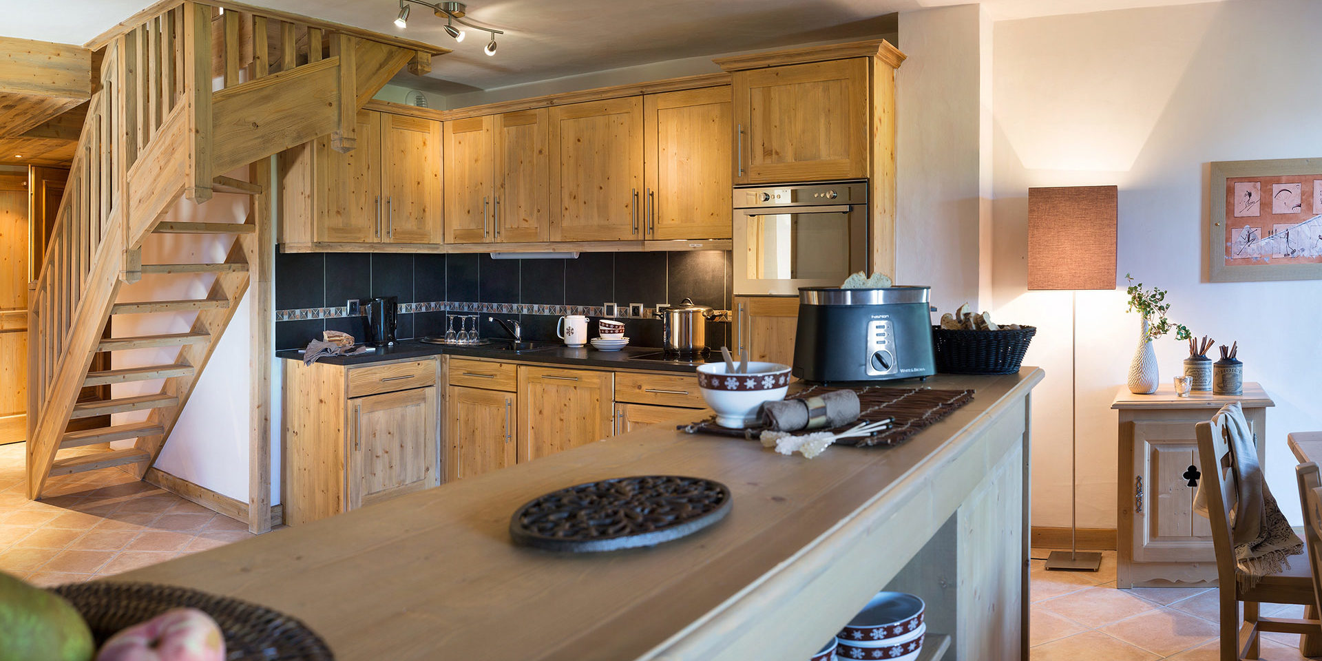 CGH Le Village de Lessy Le Grand Bornand Aravis Frankrijk wintersport skivakantie luxe houten keuken fruit broodrooster trap bloemen eettafel stoel schilderij