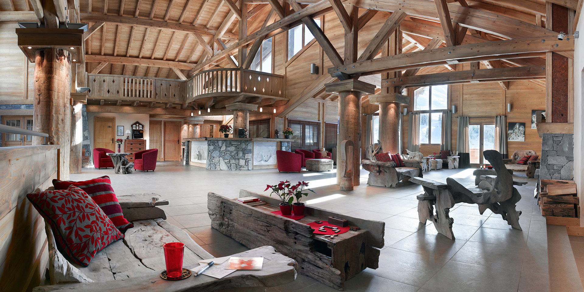 CGH Le Village de Lessy Le Grand Bornand Aravis Frankrijk wintersport skivakantie luxe receptie houten natuurlijke banken rode kussens fauteuils houten balken