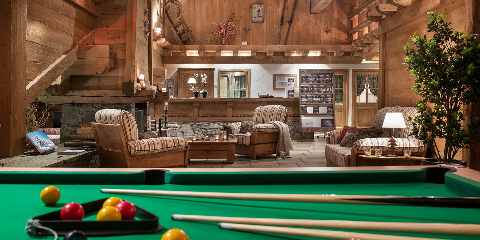 CGH Les Alpages de Champagny Champagny en Vanoise Paradiski Frankrijk wintersport skivakantie luxe receptie biljard keu fauteuils kaarsen open haard slee hout