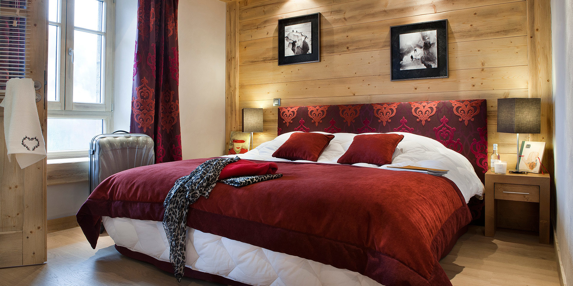 CGH Les Chalets d Angele Chatel Les Portes du Soleil Frankrijk wintersport skivakantie luxe slaapkamer 2-persoonsbed bedsprei koffer raam hout schilderijen