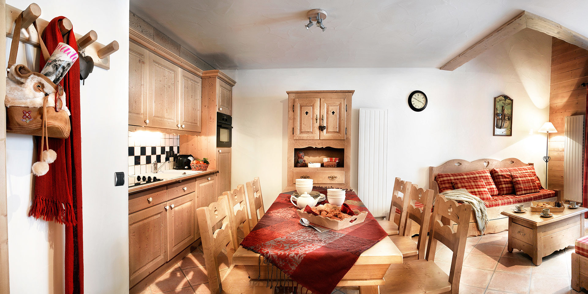 CGH Les Fermes de Sainte Foy Sainte Foy Sainte Foy Tarentaise Frankrijk wintersport skivakantie luxe gedekte eettafel stoelen bank hogh tea klok keuken fruit houten kast