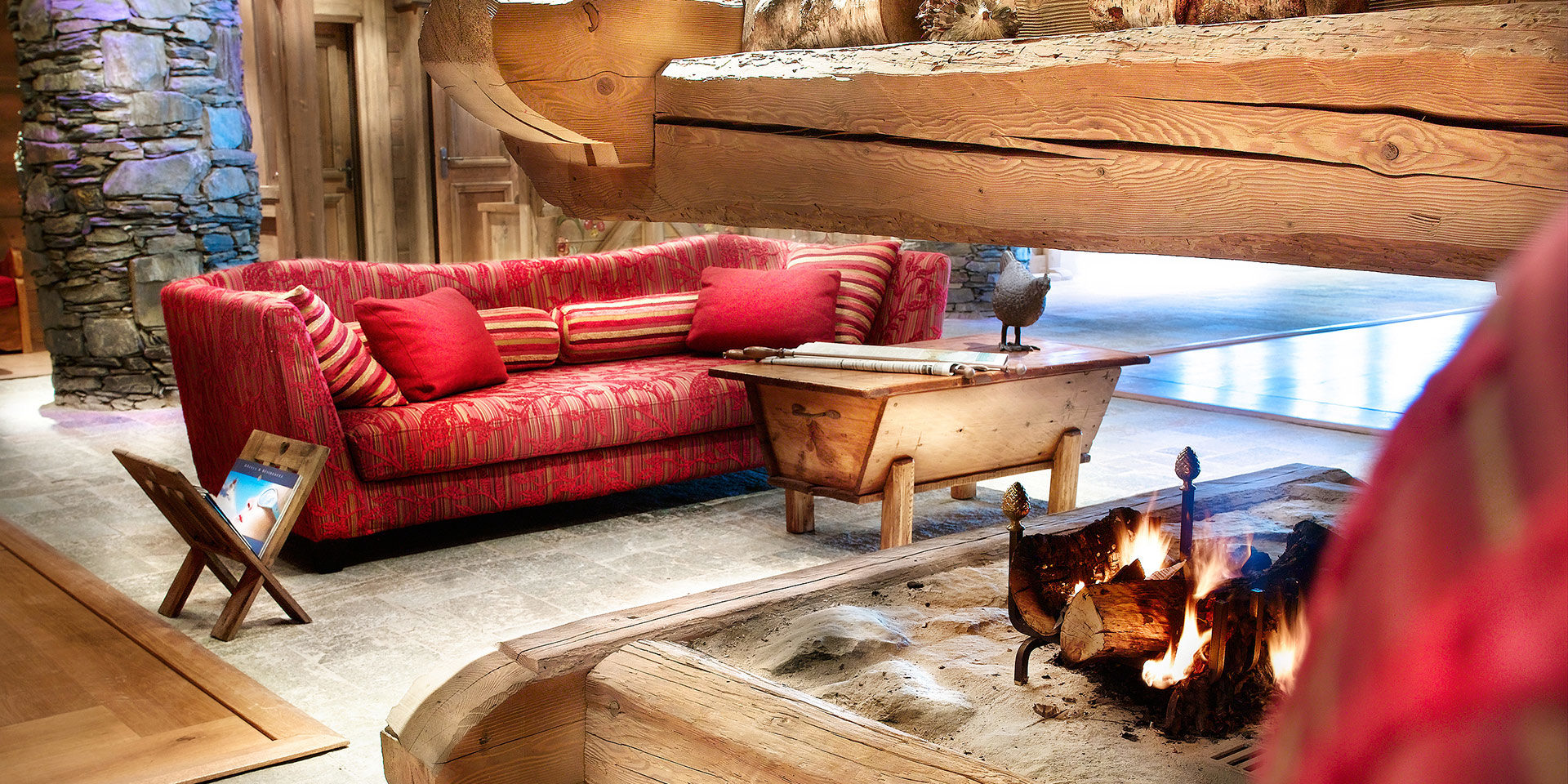 CGH Les Fermes de Sainte Foy Sainte Foy Sainte Foy Tarentaise Frankrijk wintersport skivakantie luxe receptie open haard kip rode bank hout boeken stenen pilaar