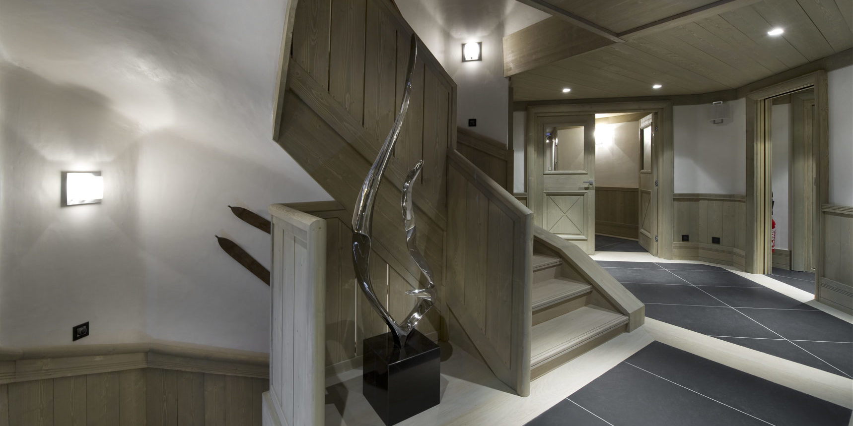 Le K2 Palace Suite-Chalet Concordia Courchevel Les 3 Vallees Frankrijk wintersport skivakantie luxe houten trap grijze plavuizen beeld kunst