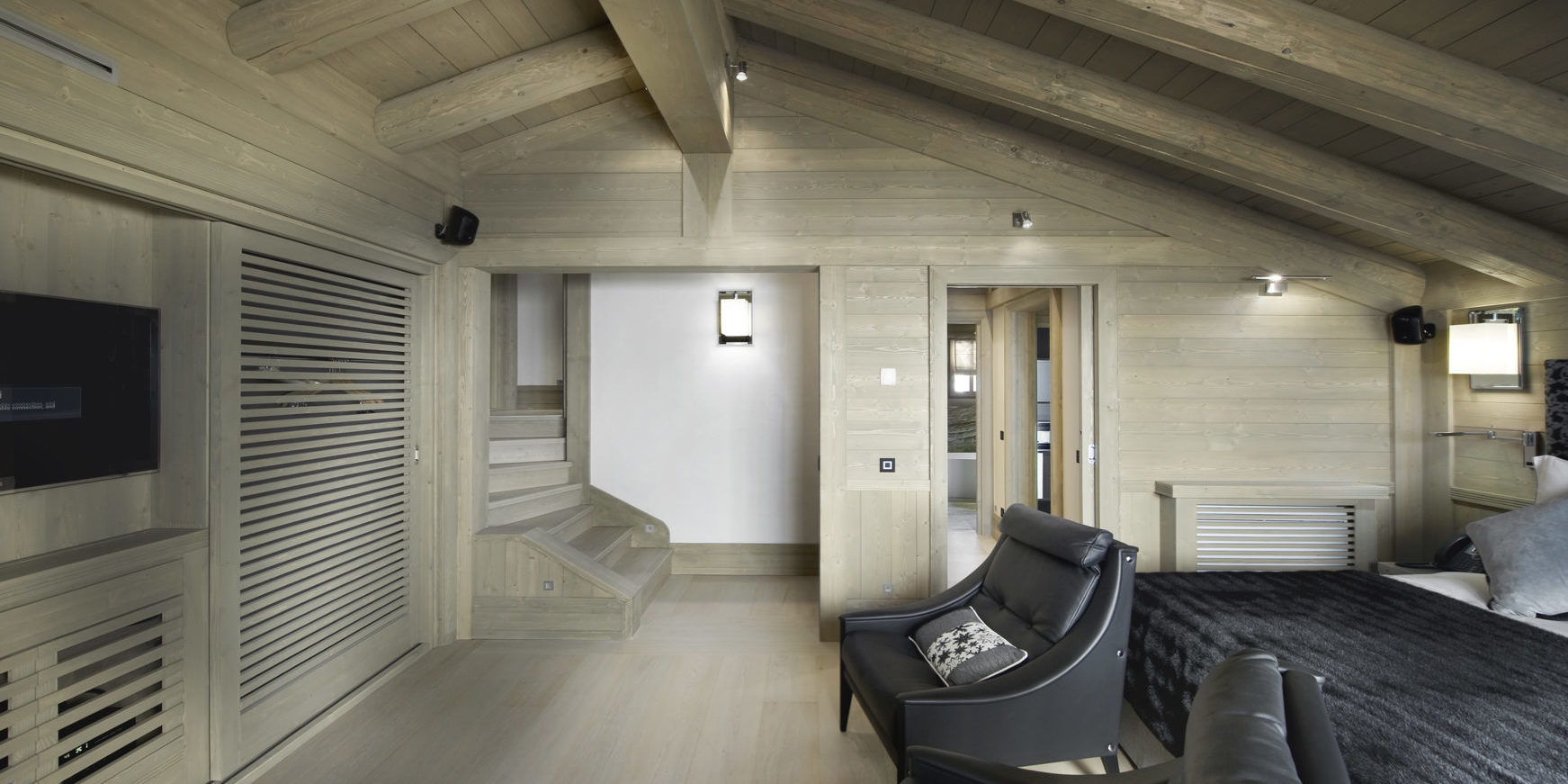 Le K2 Palace Suite-Chalet Concordia Courchevel Les 3 Vallees Frankrijk wintersport skivakantie luxe slaapkamer 2-persoonsbed zwart leren fauteuils TV trap houten balken