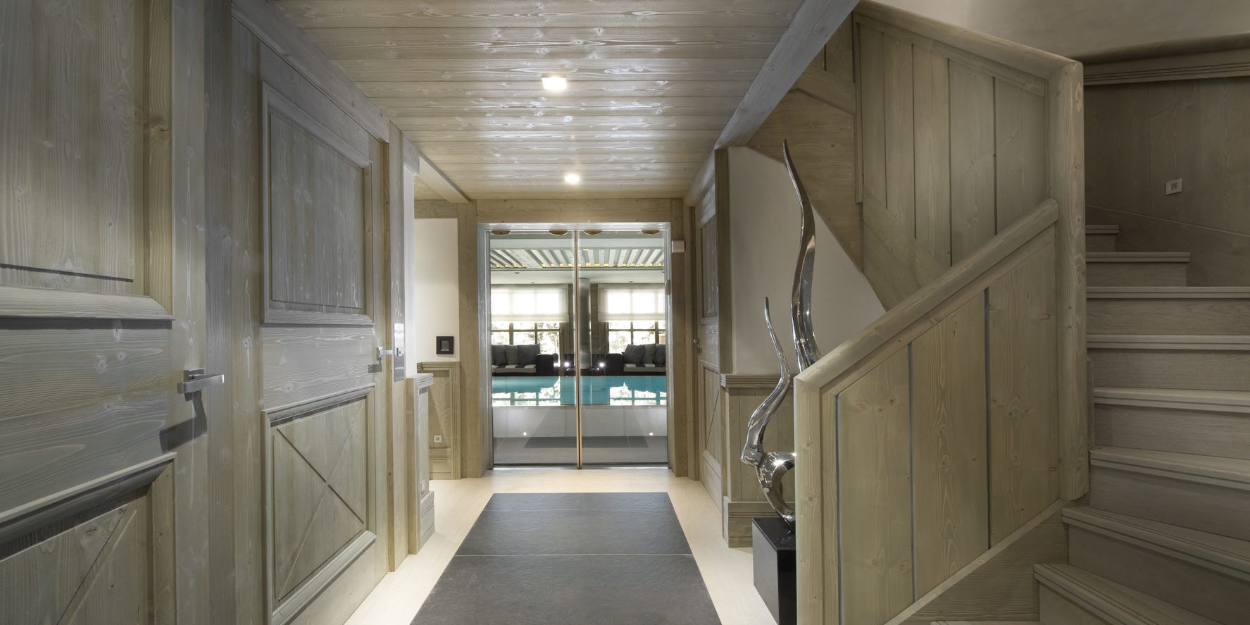 Le K2 Palace Suite-Chalet Hidden Peak Courchevel Les 3 Vallees Frankrijk wintersport skivakantie luxe gang houten trap beeld kunst zwembad