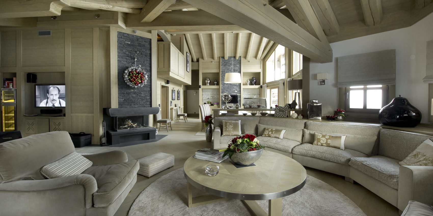 Le K2 Palace Suite-Chalet Hidden Peak Courchevel Les 3 Vallees Frankrijk wintersport skivakantie luxe living ronde zithoek witte banken fauteuil open haard houten balken