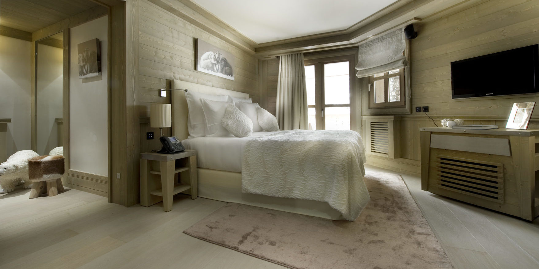 Le K2 Palace Suite-Chalet Hidden Peak Courchevel Les 3 Vallees Frankrijk wintersport skivakantie luxe slaapkamer 2-persoonsbed vloerkleed TV hout hocker