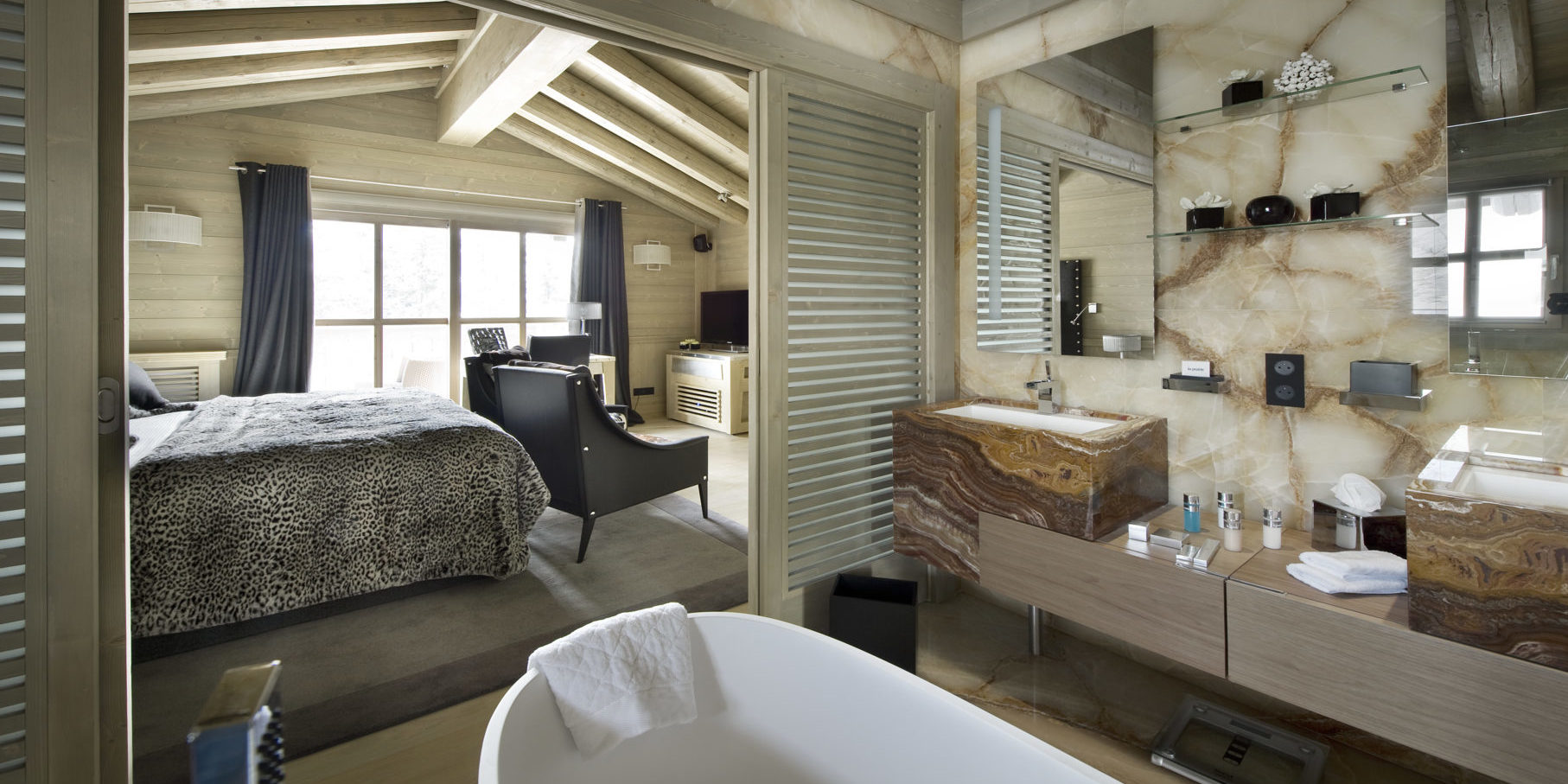 Le K2 Palace Suite-Chalet Hidden Peak Courchevel Les 3 Vallees Frankrijk wintersport skivakantie luxe slaapkamer fauteuils badkamer vrijstaand wit bad dubbele wasbak