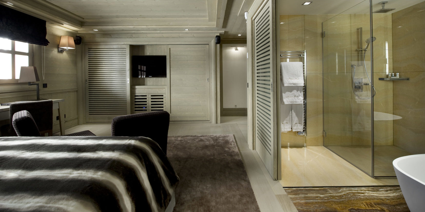 Le K2 Palace Suite-Chalet Hidden Peak Courchevel Les 3 Vallees Frankrijk wintersport skivakantie luxe slaapkamer vloerkleed bureau fauteuils TV douche handdoeken handdoekenrek