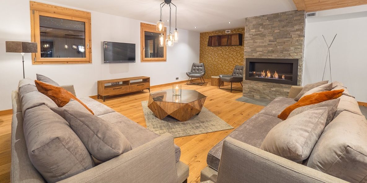 Appartement Colibri Uno Morzine Les Portes du Soleil Frankrijk wintersport skivakantie luxe living banken salontafel kaars vloerkleed hanglamp open haard ramen