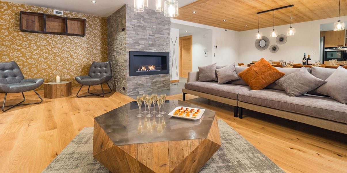Appartement Colibri Uno Morzine Les Portes du Soleil Frankrijk wintersport skivakantie luxe salontafel Champagne hapjes vloerkleed bank kussens fauteuils open haard