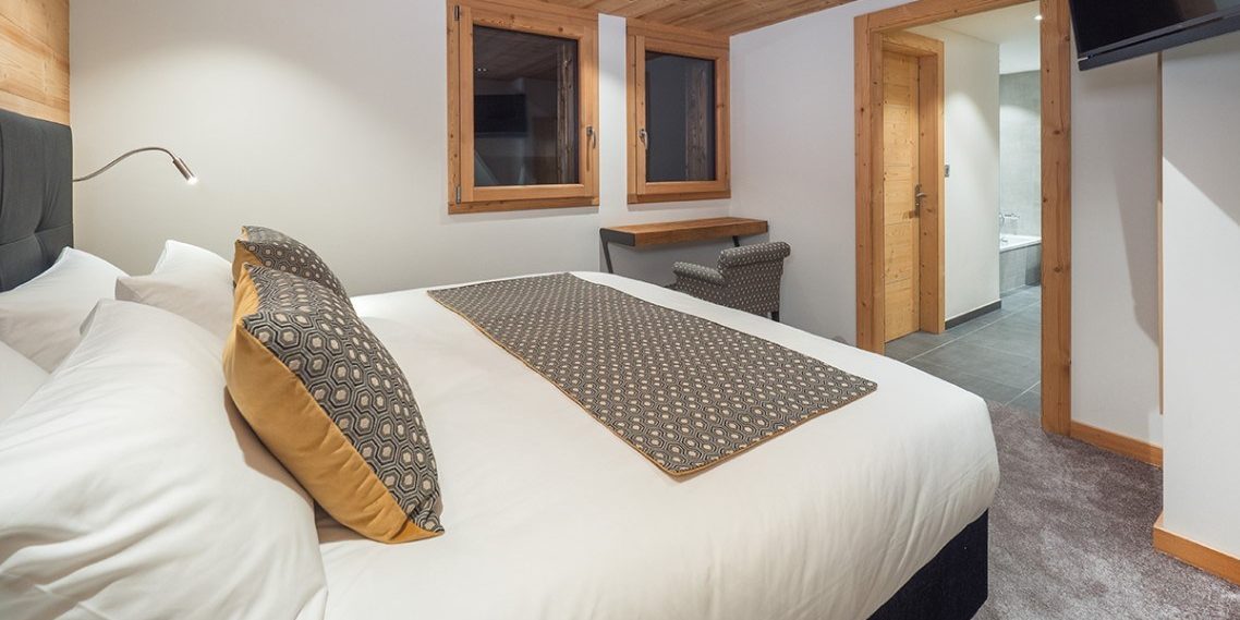 Appartement Colibri Uno Morzine Les Portes du Soleil Frankrijk wintersport skivakantie luxe slaapkamer 2-persoonsbed bedsprei TV bureau ramen hout